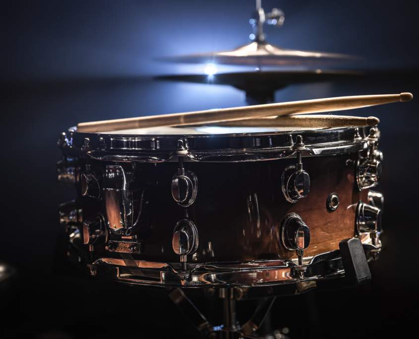 Nahaufnahme einer glänzenden Snare-Drum mit Drumsticks